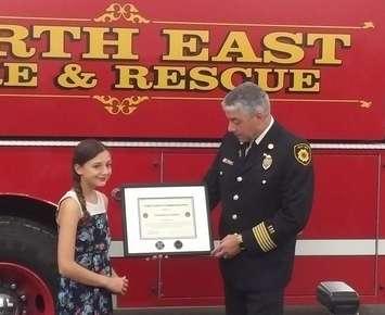 Hannah Sims receives the Fire Chief's Commendation certificate from Perth East and West Perth Chief Bill Hunter, Thurs. Oct. 5th (photo submitted)