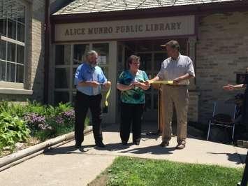 Sue Steip of the Wingham Friends of the Library Cuts the ribbon on the now named Alice Munro Public Library. (Photo by Ryan Brandt)