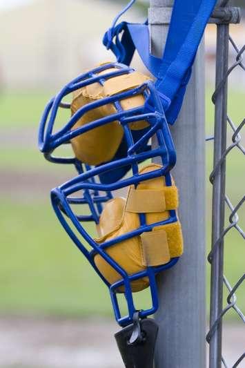 Umpires mask hanging on a backstop post. © Can Stock Photo / Joe_Photo