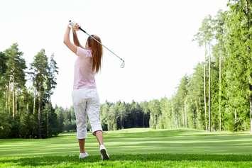 Young woman playing golf. © Can Stock Photo / Deklofenak