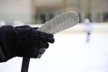 Ice hockey stick in the hand of a player. © Can Stock Photo / SergeyKuznecov