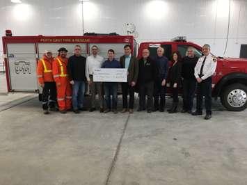 Perth East Mayor Bob McMillan (centre holding cheque) satands with municipal staff and Union Gas reps inside the new Milverton Fire Department, as Union Gas makes a $1,000 donation toward new CO alarms. (Photo by Ryan Drury)